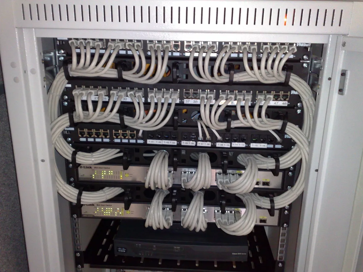 Ethernet switch'leri, yama panelleri ve düzenli kablolama içeren 19 inç bir sunucu dolabı